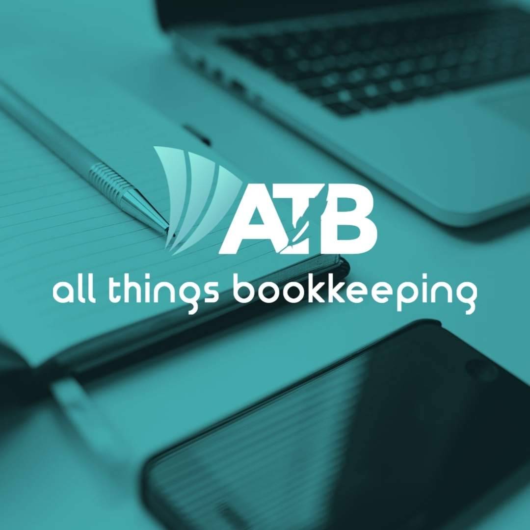 All Things Bookkeeping logo on a teal overlay with a notepad, pen, smartphone, and laptop in the background.